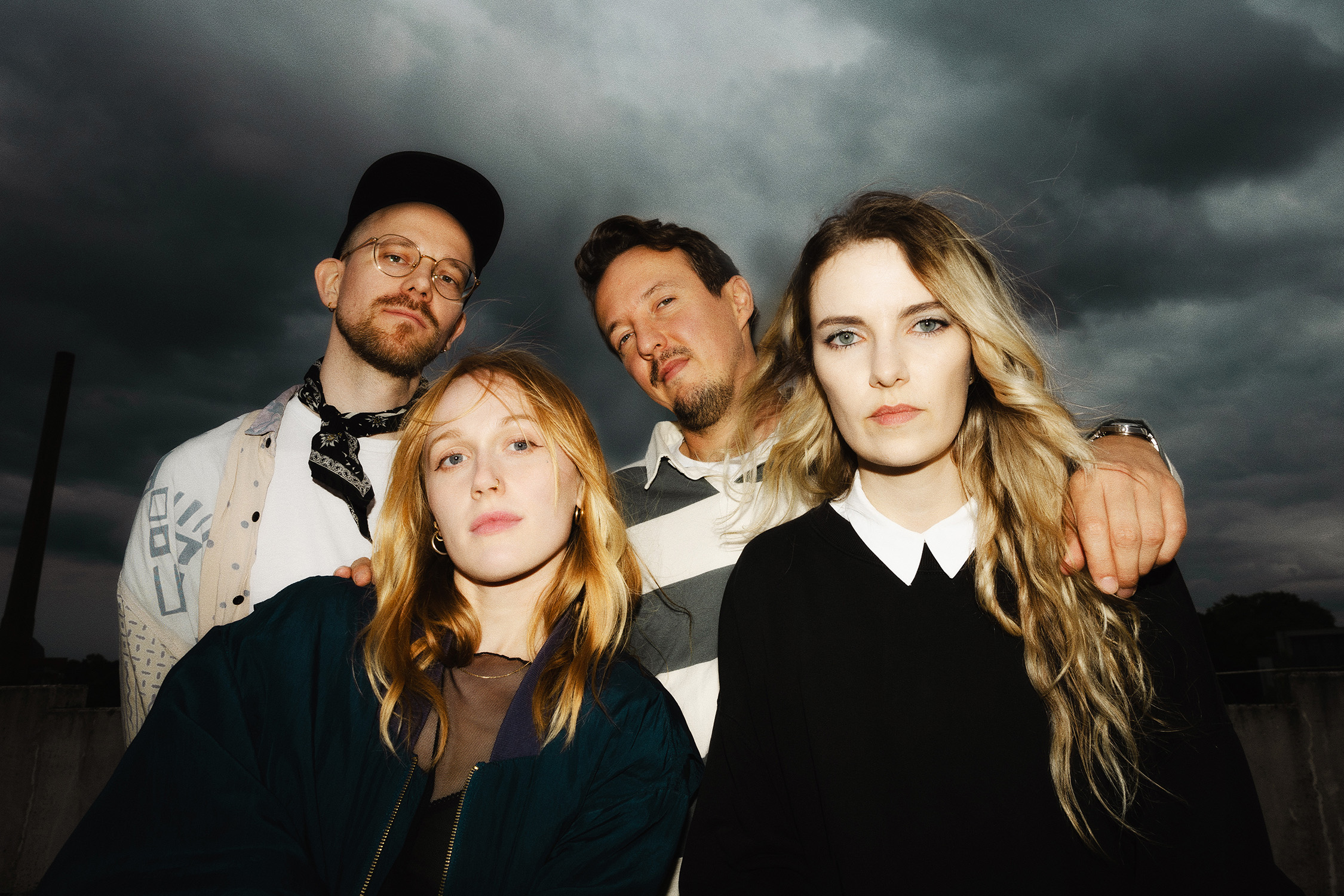 Plastic Peaches 2026 infront of a dark cloudy sky. Photo by Plastic Peaches